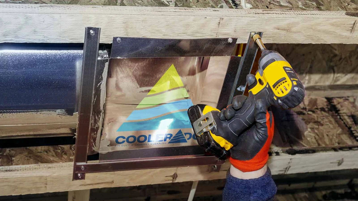 Ductwork being secured with a drill, with Coolerado branding on the duct